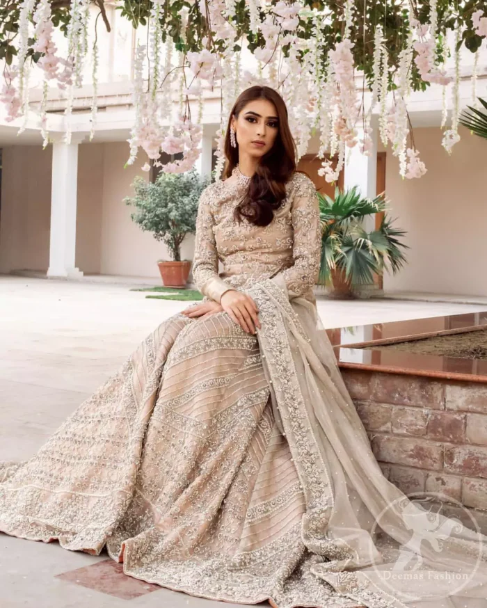 This outfit is adorned with kora, dabka, tilla, sequins and pearls. It is decorated with floral embellishments. It is overlapping shirt which adds to the look. It comes with heavy embellished lehengha allured with geometrical pattern all over it which has thick border on hemline. Tissue dupatta accompanies the garment. The dupatta has embellished borders on all four sides and small floral motifs all over it. The garment is lined with medium silk.