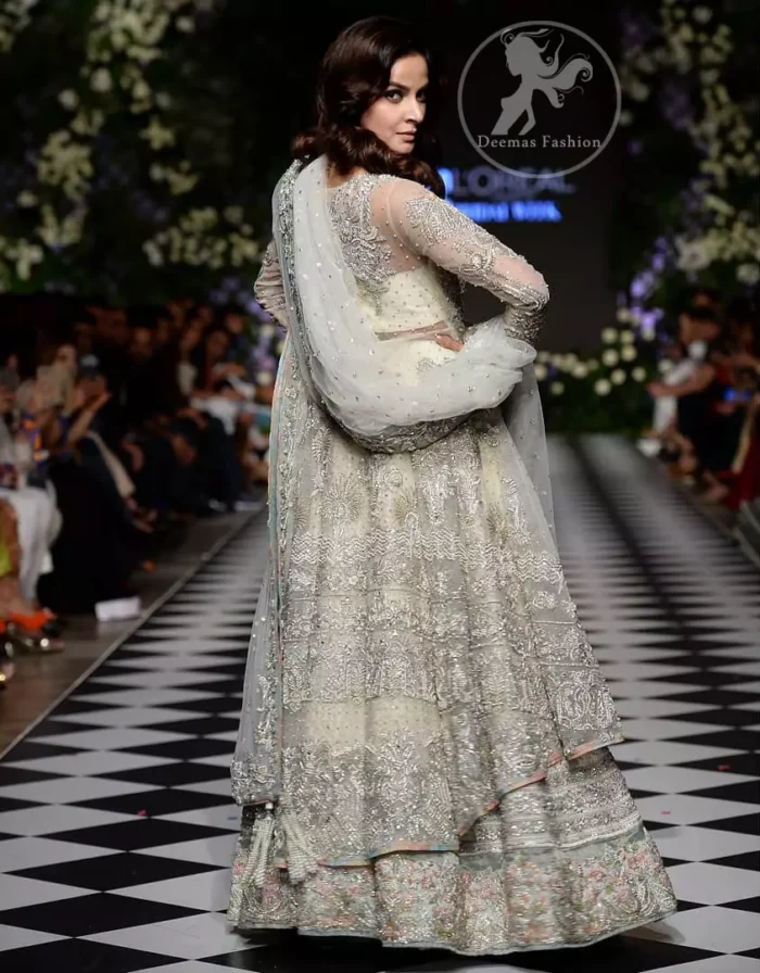 Feel glamorous in our ivory back trail frock with fascinating embellishment on neckline with silver kora, dabka, pearl and sequins. The detailed embellishment at the daaman instantly draws attention. It comes with an exquisite lehenga with thick embroidered borders to give it a regal look. The outfit is finished by beautiful applique embellished lehenga. It is coordinated with tissue dupatta which is sprinkled with sequins all over it. It is further furnished with four sided embellished border.