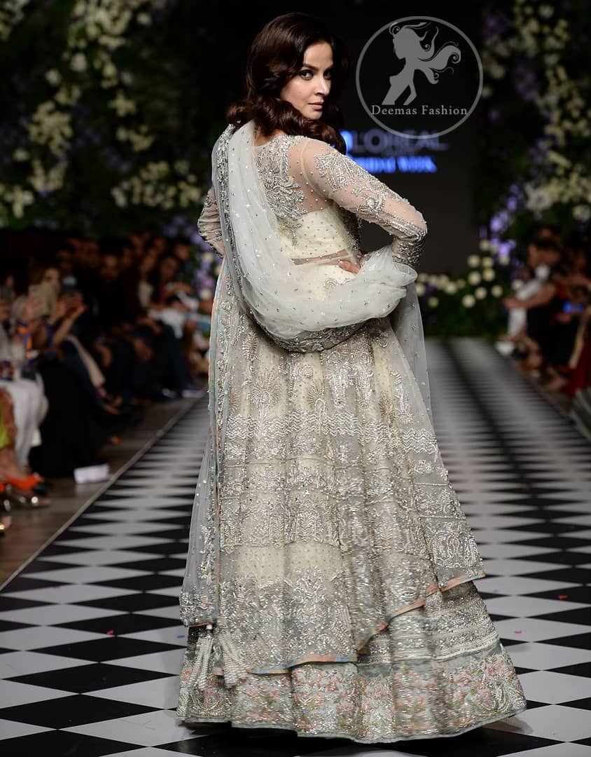Feel glamorous in our ivory back trail frock with fascinating embellishment on neckline with silver kora, dabka, pearl and sequins. The detailed embellishment at the daaman instantly draws attention. It comes with an exquisite lehenga with thick embroidered borders to give it a regal look. The outfit is finished by beautiful applique embellished lehenga. It is coordinated with tissue dupatta which is sprinkled with sequins all over it. It is further furnished with four sided embellished border.