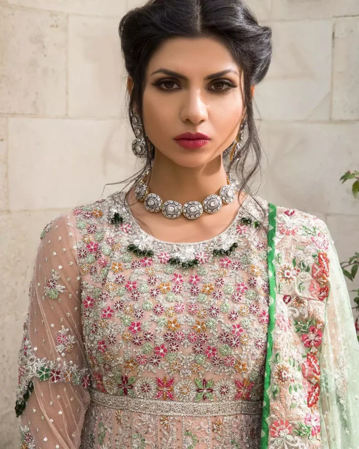 Opt for our ivory multiple-panel anarkali dress with exquisite embellishment on the bodice with pearls, sequins and silver kora, dabka. The daaman comprises of borders highlighted with floral embellished pattern. It is finished with deep blush frilled lehengha which adds to the bling. Dupatta is allured with four sided embellished border and sprinkled with stones all over it.