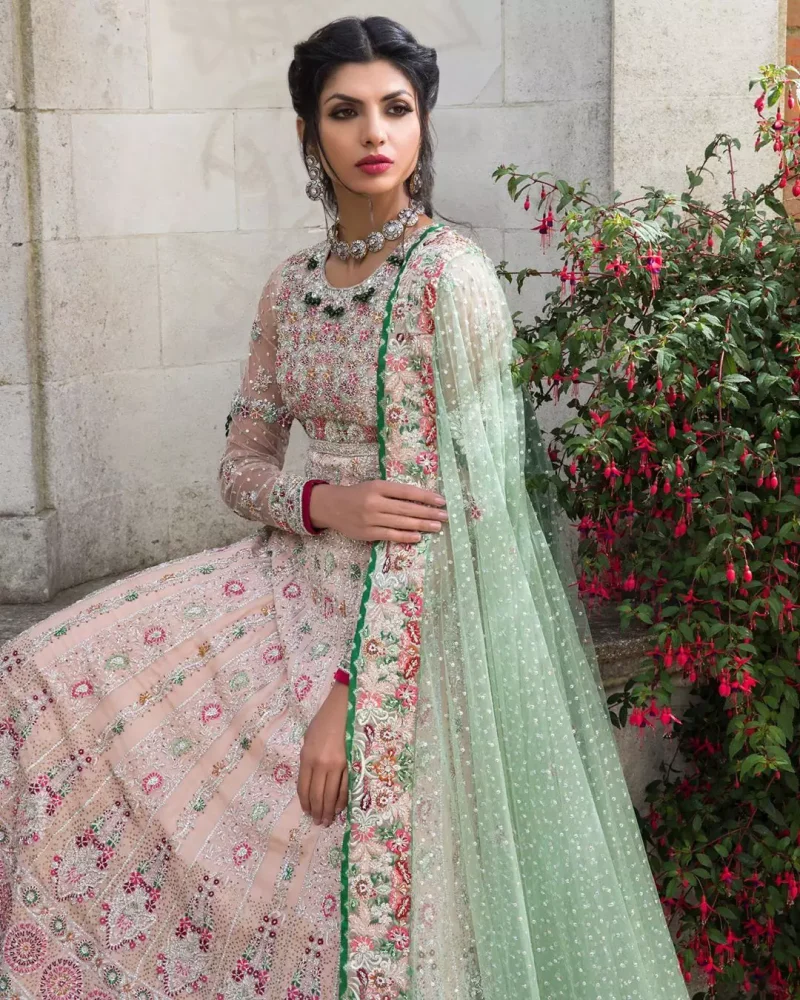 Opt for our ivory multiple-panel anarkali dress with exquisite embellishment on the bodice with pearls, sequins and silver kora, dabka. The daaman comprises of borders highlighted with floral embellished pattern. It is finished with deep blush frilled lehengha which adds to the bling. Dupatta is allured with four sided embellished border and sprinkled with stones all over it.