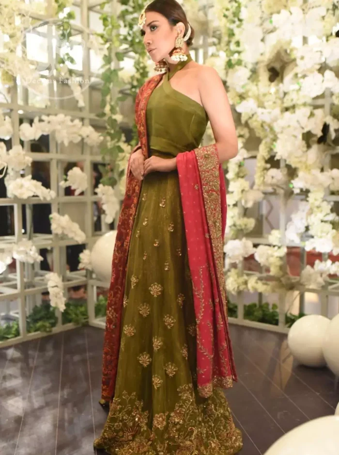 This dress is beautifully decorated with heavy embroidery. It is highlighted with dull golden kora, dabka, tilla, sequins and pearls. Fish lehengha is fully embellished.Blouse is scalloped. It comes with beautifull upper gown, sprinkled with sequins all over it. It is coordinated with chiffon dupatta which is sprinkled with sequins all over it.