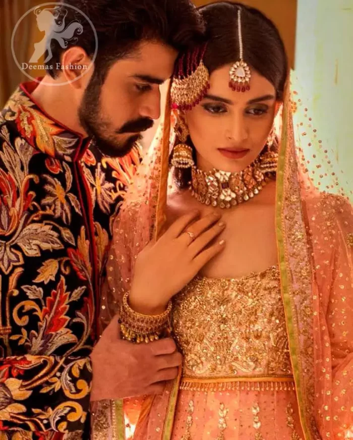 A handful of stardust on a contemporary dress, crafted delicately with dainty floral embroidery and gotta work embroidery. It is beautifully captivated with golden kora dabka, pearl and kundan work. It is finished with heavy embroidered and lace on border. Paired up with churidar pajama and net dupatta with sprinkled sequins and piping on all sides.