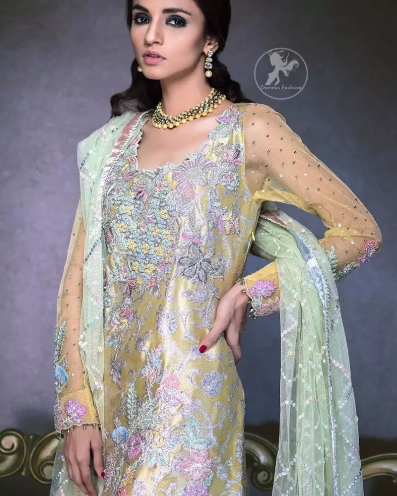 This dress is beautifully decorated with heavy embroidery. It is highlighted with dull golden kora, dabka, tilla, sequins and pearls. Fish lehengha is fully embellished.Blouse is scalloped. It comes with beautifull upper gown, sprinkled with sequins all over it. It is coordinated with chiffon dupatta which is sprinkled with sequins all over it.