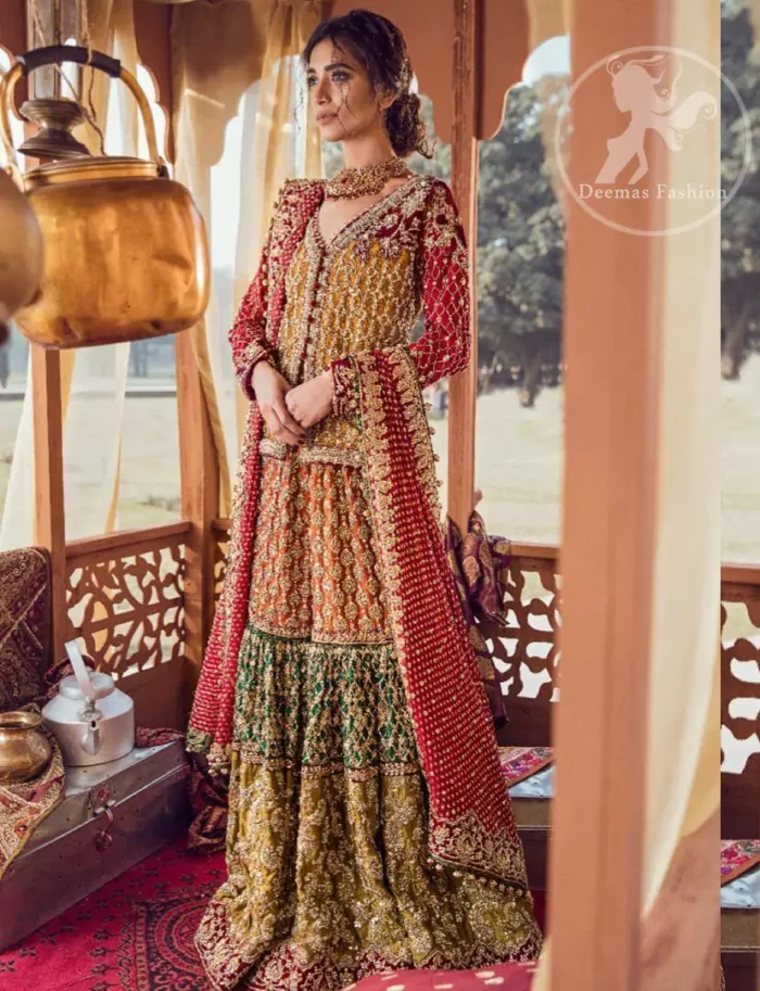 Exquisite detailing radiates elegance in this stunning short shirt. Redefine your style in this traditional and versatile ensemble ornamented with floral and geometric embroidery furnished with golden kora dabka, kundan and pearls. It comes with multiple colored traditional gharara done with zerdozi work in patterns and embroidered applique details on bottom. Complete the look with red dupatta having embroidered borders on all sides and sequins spray on the ground.
