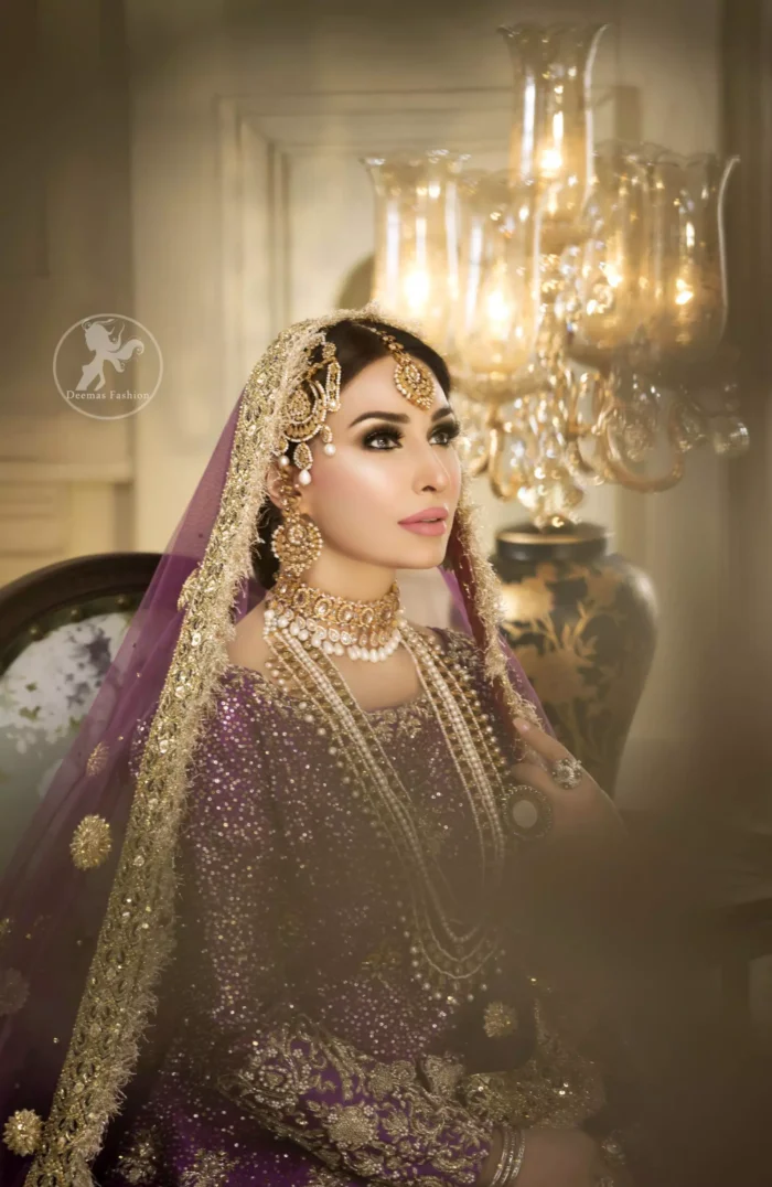 Reflecting royalty and the majestic beauty of statuesque shape and silhouette this bridal dress is perfect for your special day. This dress is beautifully decorated with heavy embroidery. It is highlighted with golden kora, dabka, tilla, sequins and pearls. The short shirt is decorated from neckline and scalloped hemline is decorated with zardosi work. Lehenga is enhanced with floral patterns all over with golden embellishment.  It is coordinated with chiffon dupatta which is sprinkled with small floral motifs all over.