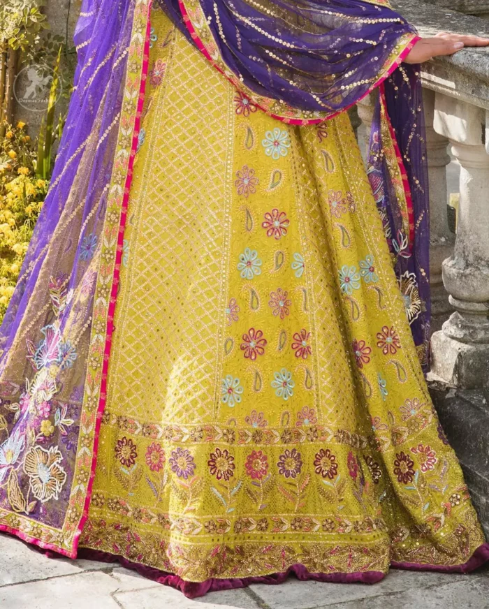 This dress is perfect for menhndi day. The shocking pink blouse is beautifully decorated with antique embroidery. It is highlighted with dull golden kora, dabka, tilla, sequins and pearls. Lehenga has small floral motifs, geometric pattern and detailed zardosi work and rich hemline. It is coordinated with purple chiffon dupatta which have verticle sequins lines all over. Furthermore it is enhanced with lace on all four sides of border.