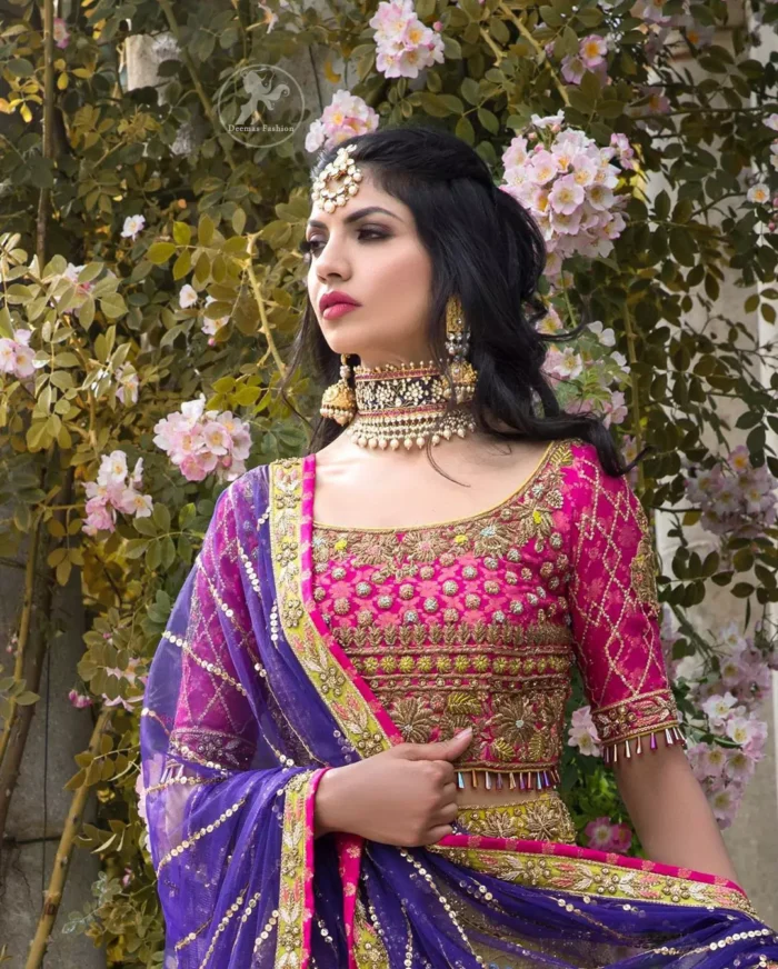 This dress is perfect for menhndi day. The shocking pink blouse is beautifully decorated with antique embroidery. It is highlighted with dull golden kora, dabka, tilla, sequins and pearls. Lehenga has small floral motifs, geometric pattern and detailed zardosi work and rich hemline. It is coordinated with purple chiffon dupatta which have verticle sequins lines all over. Furthermore it is enhanced with lace on all four sides of border.