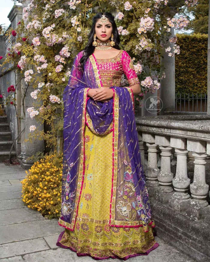 This dress is perfect for menhndi day. The shocking pink blouse is beautifully decorated with antique embroidery. It is highlighted with dull golden kora, dabka, tilla, sequins and pearls. Lehenga has small floral motifs, geometric pattern and detailed zardosi work and rich hemline. It is coordinated with purple chiffon dupatta which have verticle sequins lines all over. Furthermore it is enhanced with lace on all four sides of border.