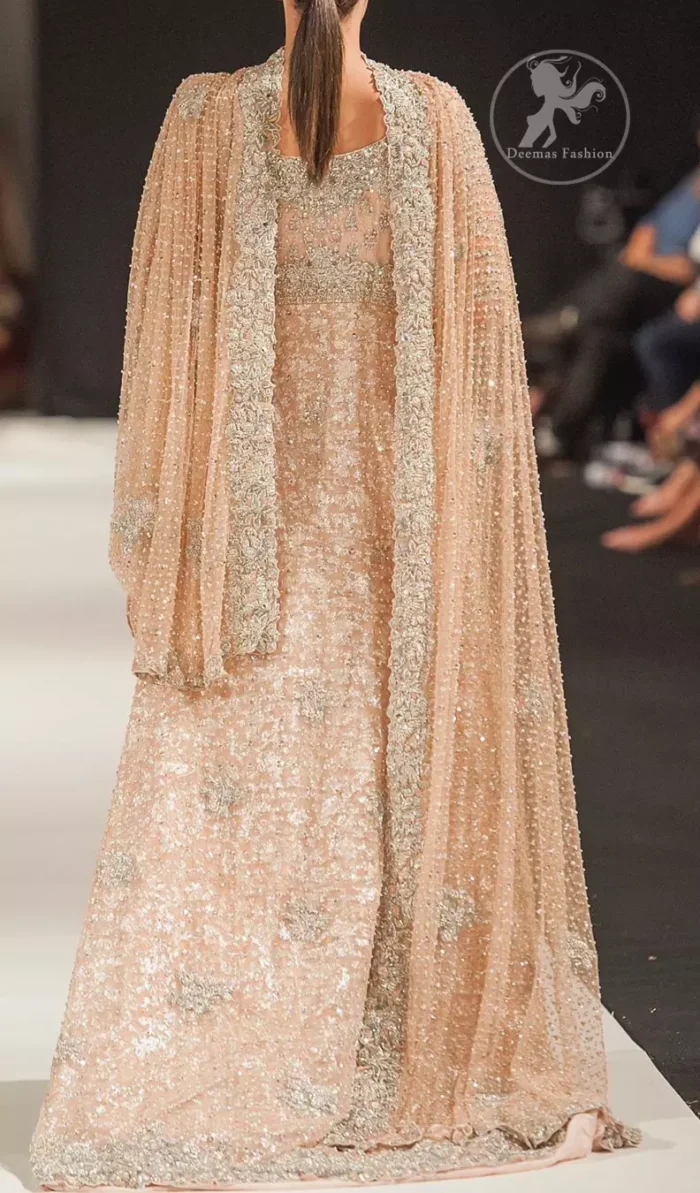 This dress is beautifully decorated with heavy embroidery. It is highlighted with dull golden kora, dabka, tilla, sequins and pearls. Fish lehengha is fully embellished.Blouse is scalloped. It comes with beautifull upper gown, sprinkled with sequins all over it. It is coordinated with chiffon dupatta which is sprinkled with sequins all over it.