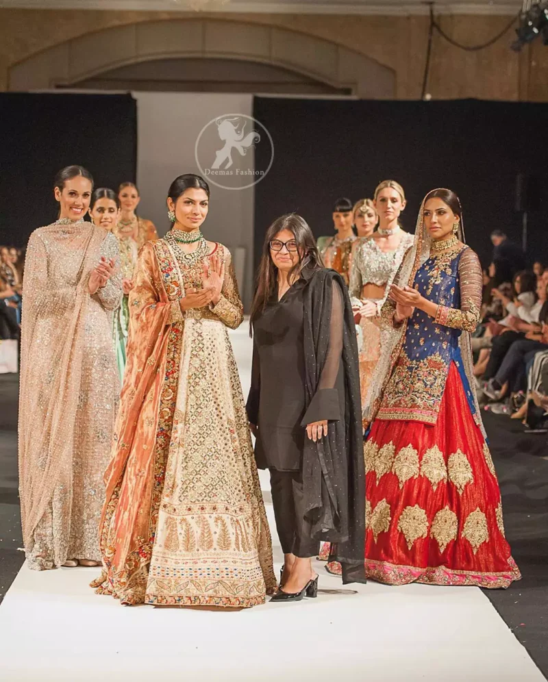 This dress is beautifully decorated with heavy embroidery. It is highlighted with dull golden kora, dabka, tilla, sequins and pearls. Fish lehengha is fully embellished.Blouse is scalloped. It comes with beautifull upper gown, sprinkled with sequins all over it. It is coordinated with chiffon dupatta which is sprinkled with sequins all over it.