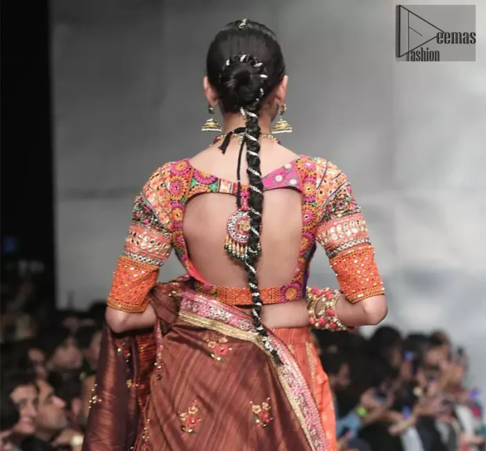 This dress is majestic beauty and perfect for mehndi mayon day. Delicately crafted and personifying chic elegance with an element of grandiose. A full heavily embellished blouse with multiple color resham thread embroidery and mirror work details. Having half sleeves adorned with mirror work. It comprises with self printed lehenga finishing with dull golden lace at the end. Style it confidently with chocolate brown dupatta with thick embellished border on the front and comparatively lighter work border on long edges. Medium and tiny sized ornamental motifs scattered all-over.