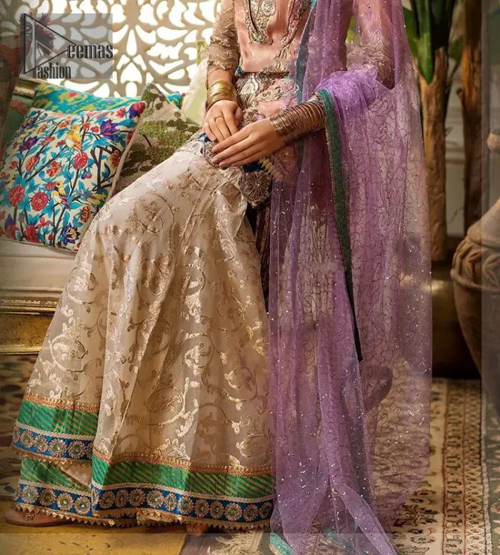 Add some super cool twist to your look with this outfit on your nikah. Gussy up in this luxuriously designed shirt emboldened with intricate embroidery along with beautiful rich patterns and delicate applique details at the daaman. Furthermore this super stunning shirt is made of rich floral embroidery which is further enhanced with zardosi work. Having full length sleeves adorned with scalloped finishing. Style it up with artfully coordinated ivory sharara finessed with lace and applique details at the bottom. The outfit is beautifully coordinated with light purple dupatta with embellished lace borders on all four sides and scattered sequins all over.