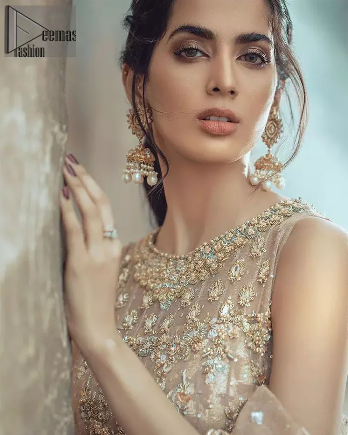 This bridal dress executing heavily hand crafted art of zardosi, kora and dabka with splashes of golden and silver is a classical visit to feminine personification. The heavenly handcrafted lehenga showcases the traditional art of zardozi, nakshi, kundan, kora and dabka; adorning the intricate and meticulous hand embellishments giving it a wholesome gentle stance paired with a regal gold sleeveless blouse. The bottom of the lehenga is enhanced with embellished applique with zardosi work and resham embroidery. It comprises with organza dupatta having four sided matha patti style border and scattered sequins all over it.