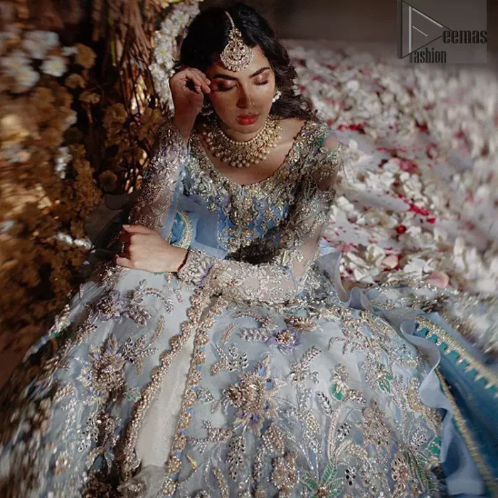 Reflecting royalty and the majestic beauty of statuesque shape and silhouette this dress is perfect for your walima and engagement function. Add some super cool twist to your look with this subtle colors in intricately embroidered frock. Capture the attention with fascinating embellishment on neckline with silver and dull golden kora, dabka, pearl and sequins. Having full length sleeves adorned with floral motifs. It comprises with ivory sharara. Thin border with floral motifs on all four sides of the dupatta which have gold tila embroidery with kora and dabka. 