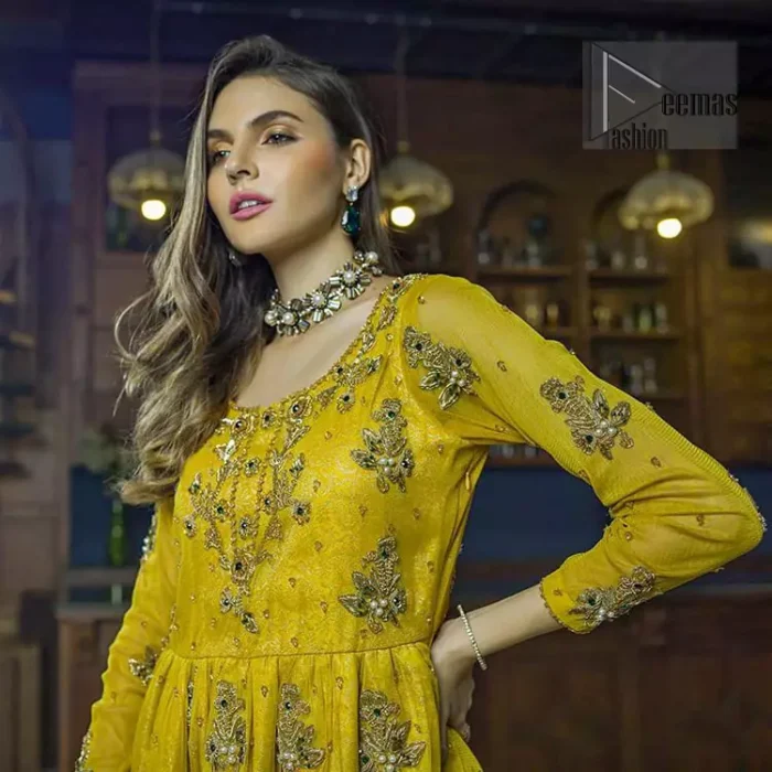 This dress is perfect for mehndi day. Delicately crafted and personifying chic elegance with an element of grandiose. This mehendi and mayun dress is beautifully sculptured with floral embroidery on neckline adorned with scattered embellished with dull golden kora, dabka, pearl and sequins work all over. Having full length sleeves adorned with motifs. It comprises with mehndi green gharara sprinkled with sequins to convey a classic style. Beautifully coordinated with bottle green dupatta with thick lace border.