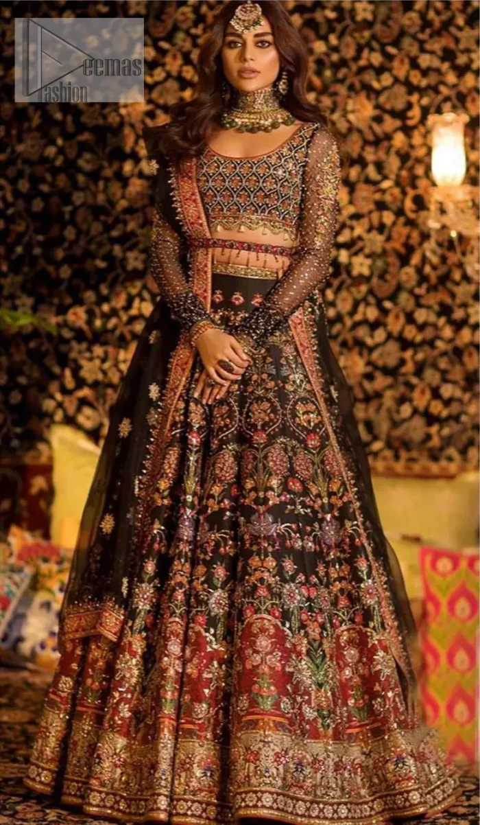 Tradition meets modernity. Go glam in our black traditional lehenga blouse. This outfit bursts of vibrant colors and sumptuous details of zardozi, gota, kora and dabka is a perfect Mehndi ensemble. It is aesthetically designed with thick borders and floral bunches refined the classical royal look. Blouse is decorated with geometric patterns having full sleeves adorned with zardosi work and sprinkled sequins. Style it up with black net dupatta sprinkled with tiny floral motifs and four sided applique embellishment. The piece comes with a handcrafted belt.