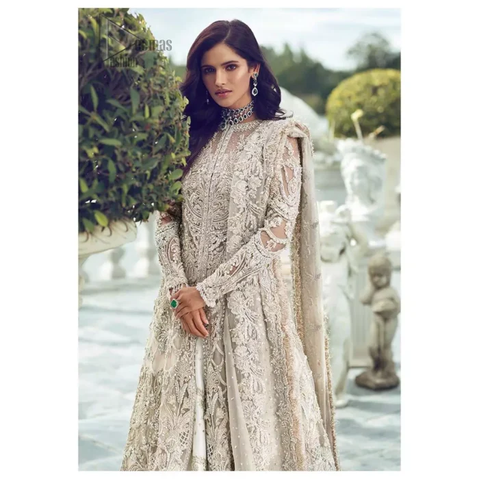 Captured in traditional silhouette, The bridal stands out due to its uniqueness and the perfect fusion of modern cut and traditional embroidery. It is highlighted with silver and light golden kora, dabka, tilla, sequins and pearls. It comes with heavily embellished front open back trail gown ornamented with floral embroidered  motifs and geometric patterns. Paired up with ivory lehenga done with light gold embroidery. It is coordinated with chiffon dupatta which is sprinkled with sequins all over it. It is further furnished with four sided border.