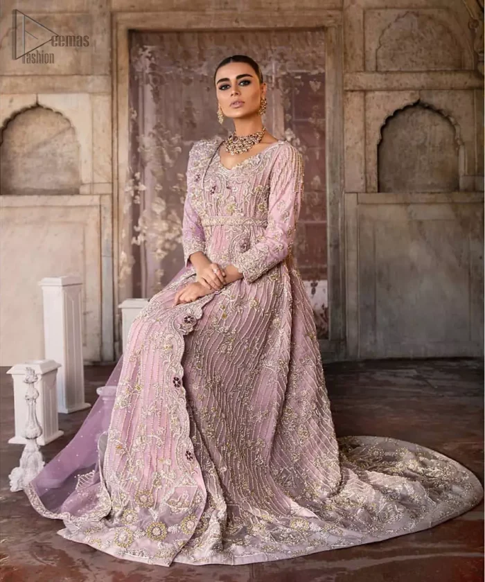Exude elegance and class in this back trail maxi finessed with beautiful embellishment. The outfit is beautifully sculptured with floral embroidery, adorned with vertical lines and fixed waist belt embellished with silver and light golden kora, dabka, tilla and sequins work all over. The back of the outfit has an artistically designed motif. The outfit is styled with a hand embellished crystal belt. It comprises with cigarette pants and light pink net dupatta ornamented with sprinkled sequins on the ground and four sided light border.