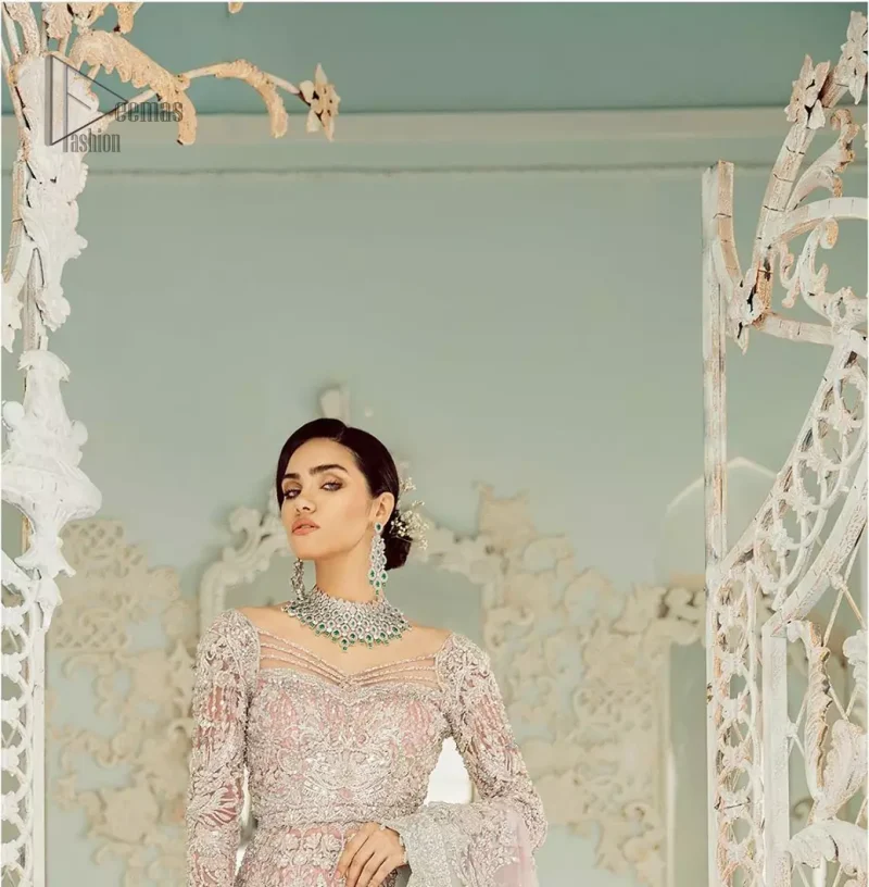 An example of beauty and elegance. Look breathtakingly stylish in this embroidered regalia furnished with intricate embroidered neckline. This ethereal maxi highlights the collision of heritage and beauty of traditional zardosi craftsmanship with modern chic silhouette. Beautifully designed sleeves is an amalgamation of geometric and floral design elements. The light pink net dupatta with chann and scalloped applique border all around the edges makes the look complete.