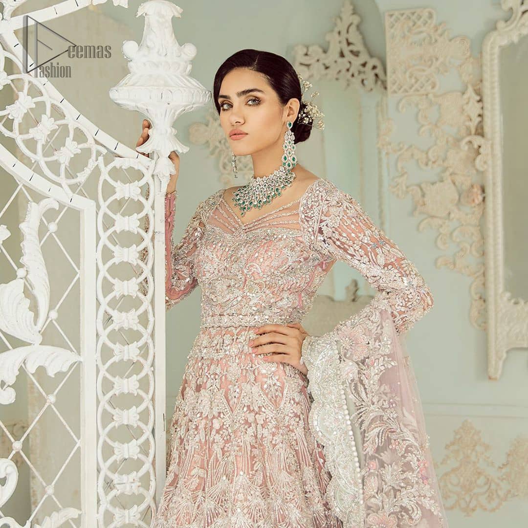 An example of beauty and elegance. Look breathtakingly stylish in this embroidered regalia furnished with intricate embroidered neckline. This ethereal maxi highlights the collision of heritage and beauty of traditional zardosi craftsmanship with modern chic silhouette. Beautifully designed sleeves is an amalgamation of geometric and floral design elements. The light pink net dupatta with chann and scalloped applique border all around the edges makes the look complete.