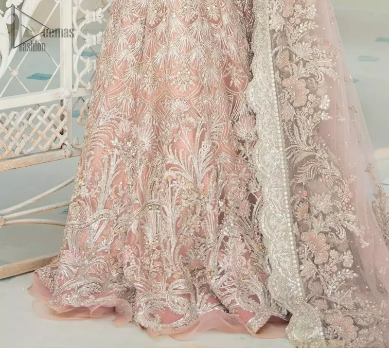 An example of beauty and elegance. Look breathtakingly stylish in this embroidered regalia furnished with intricate embroidered neckline. This ethereal maxi highlights the collision of heritage and beauty of traditional zardosi craftsmanship with modern chic silhouette. Beautifully designed sleeves is an amalgamation of geometric and floral design elements. The light pink net dupatta with chann and scalloped applique border all around the edges makes the look complete.