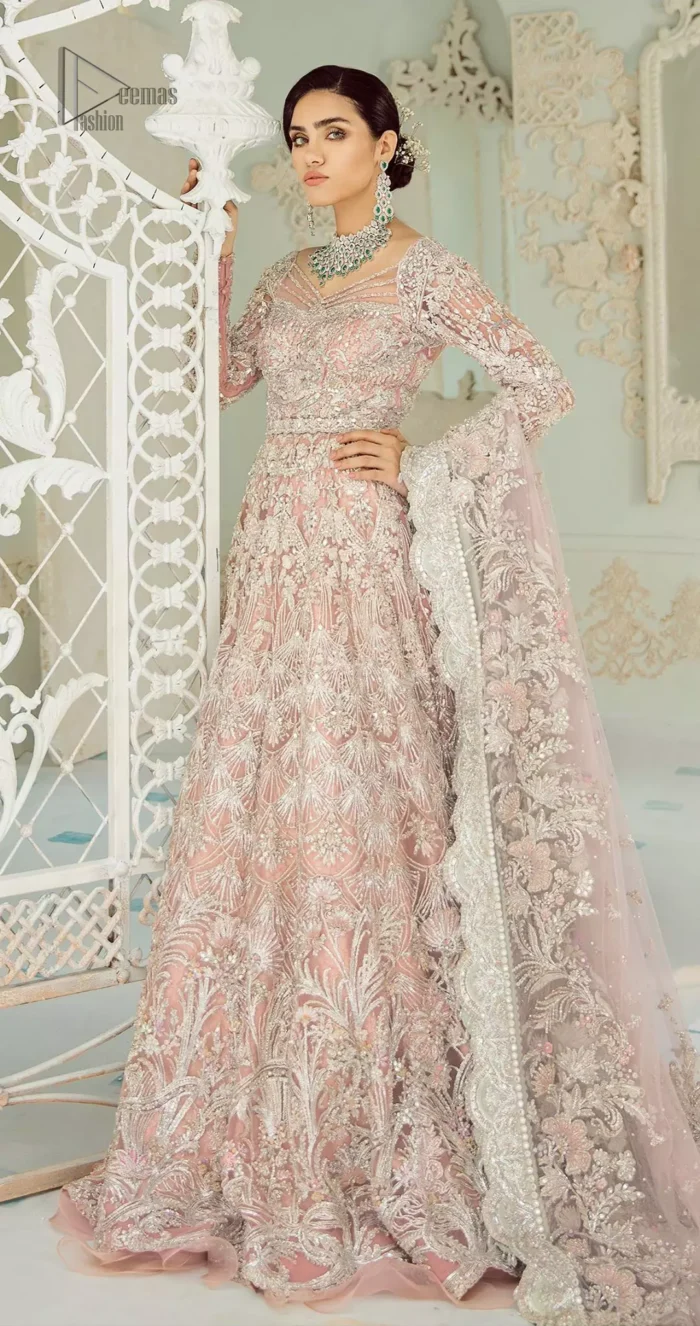 An example of beauty and elegance. Look breathtakingly stylish in this embroidered regalia furnished with intricate embroidered neckline. This ethereal maxi highlights the collision of heritage and beauty of traditional zardosi craftsmanship with modern chic silhouette. Beautifully designed sleeves is an amalgamation of geometric and floral design elements. The light pink net dupatta with chann and scalloped applique border all around the edges makes the look complete.