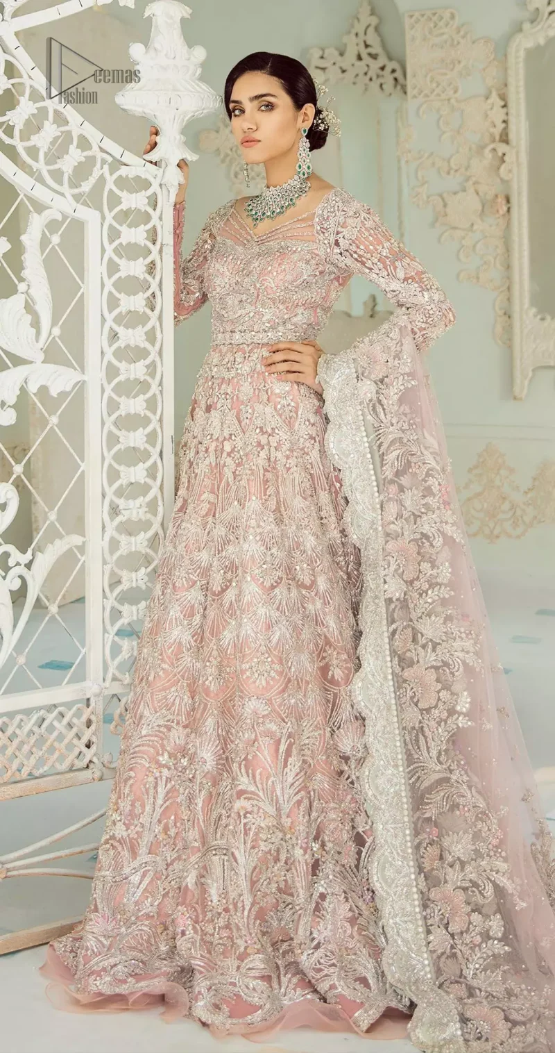 An example of beauty and elegance. Look breathtakingly stylish in this embroidered regalia furnished with intricate embroidered neckline. This ethereal maxi highlights the collision of heritage and beauty of traditional zardosi craftsmanship with modern chic silhouette. Beautifully designed sleeves is an amalgamation of geometric and floral design elements. The light pink net dupatta with chann and scalloped applique border all around the edges makes the look complete.