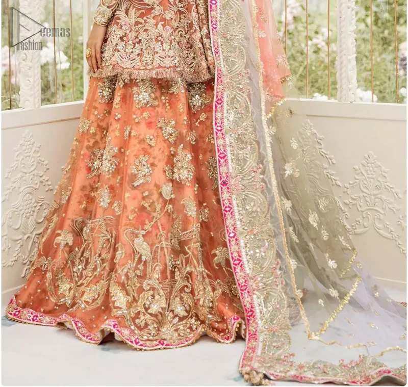 Captured in traditional silhouette, The bridal stands out due to its uniqueness and the perfect fusion of modern cut and traditional embroidery. This front open short frock is highlighted with kora, dabka, tilla, sequins and pearls. It comes with full embellished lehenga adorned with floral bunches, applique on the hemline and sequins spray all over it. It is coordinated with organza dupatta which is sprinkled with tiny floral motifs all over and a thick embellished border on all four sides with applique details.