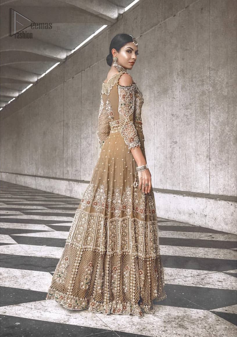 An example of beauty and elegance. Our bride makes a statement in this stunningly floraison, perfect blend of glamour and tradition with outstanding craftsmanship and gorgeous detailing. The cold shoulder blouse is stunningly embellished with intricate embroidered neckline done with light golden and silver zardosi work all over. Lehnga is compiled with zardozi embellishment which gives this festive season a flattering dimension to die for. The outfit is coordinated with beige net dupatta adorned with scattered sequins all over and four sided border.