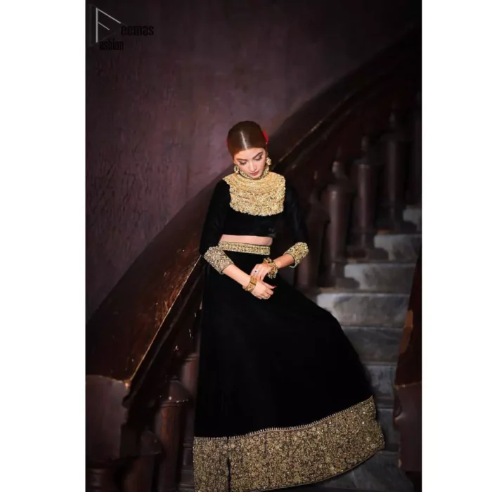 Embrace the season of festivities with this beautiful dress. This elegant ensemble turns timeless piece into a chic fantasy. The halter neck blouse is delicately hand crafted using the finest old age techniques and materials including kora, dabka, tilla, sequins, stones, and crystal. The sleeves are embellished with a thick embroidered border. Lehenga comprises of thick embroidered bottom to give it a regal look. It comes with a black net dupatta with sequins sprayed all over it .