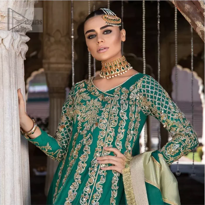 Steal the moment with our emerald green floor length angrakha emphasized with traditional neckline and intricate floral daman enhanced with light golden kora, dabka and sequins. The detailed zardosi work on sleeves and vertical panel stripes ornamented with gold kora and dabka embroidery on the bodice, the thick borders and floral bunches refined the classical royal look. Style it up with organza dupatta adorned with four sided kiran.