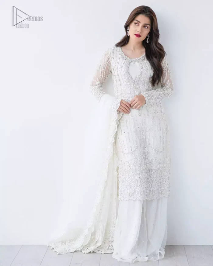 This is an ensemble that deserves to be flaunted. The ivory white shirt is an example of remarkable handiwork. With a lot of attention to detail, the intricate sequencing using glass beading and threads makes the shirt look like nothing but a dream. Furthermore the shirt is enhanced with thick embellished scalloped hemline. Sharara is magnificently decorated with scattered crystals all over. Beautifully paired it up with ivory white dupatta having four sided scalloped border.