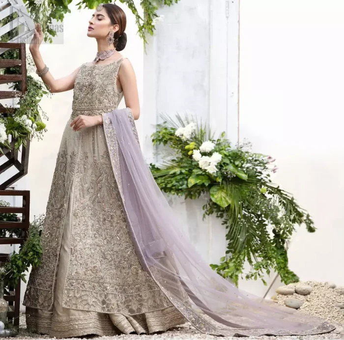 The ultimate in feminine elegance with fine detail to die for. Our bride makes a statement in this stunningly floraison, perfect blend of glamour and tradition with outstanding craftsmanship and gorgeous detailing. This front open pishwas is gorgeously decorated with floral bunches all over done with antique shaded zardozi work. It comprises with light beige jamawar lehenga with zardozi detail on the bottom. Style it up with light purple net dupatta sprinkled with sequins and four sided embellished border.