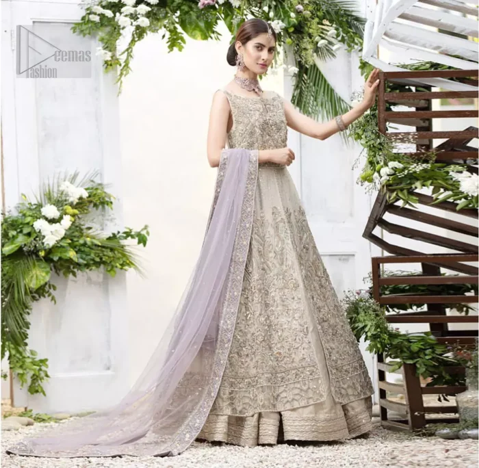 The ultimate in feminine elegance with fine detail to die for. Our bride makes a statement in this stunningly floraison, perfect blend of glamour and tradition with outstanding craftsmanship and gorgeous detailing. This front open pishwas is gorgeously decorated with floral bunches all over done with antique shaded zardozi work. It comprises with light beige jamawar lehenga with zardozi detail on the bottom. Style it up with light purple net dupatta sprinkled with sequins and four sided embellished border.