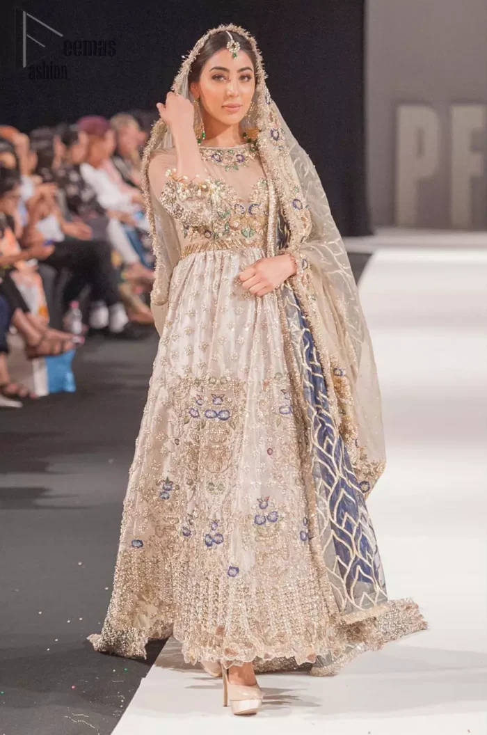 This artisan piece includes intricate hand-embellishment. This technique gives your garments a unique look, and helps to sustain a traditional craft carried out by skilled artisans across Asia. Adorned with dull golden zardozi and multiple color thread embroidery around the neckline and bodice. Furthermore the scalloped bottom is ornamented with floral jhaal, multiple color embellished floral bootis and tiny motif all over. Style it up with gray dupatta done with gotta work and cigarette pants.