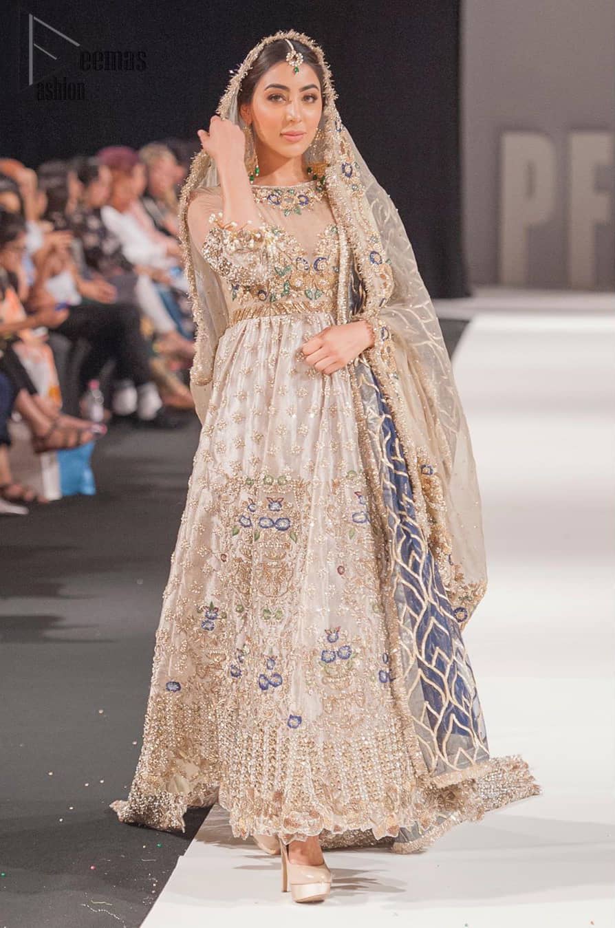This artisan piece includes intricate hand-embellishment. This technique gives your garments a unique look, and helps to sustain a traditional craft carried out by skilled artisans across Asia. Adorned with dull golden zardozi and multiple color thread embroidery around the neckline and bodice. Furthermore the scalloped bottom is ornamented with floral jhaal, multiple color embellished floral bootis and tiny motif all over. Style it up with gray dupatta done with gotta work and cigarette pants.