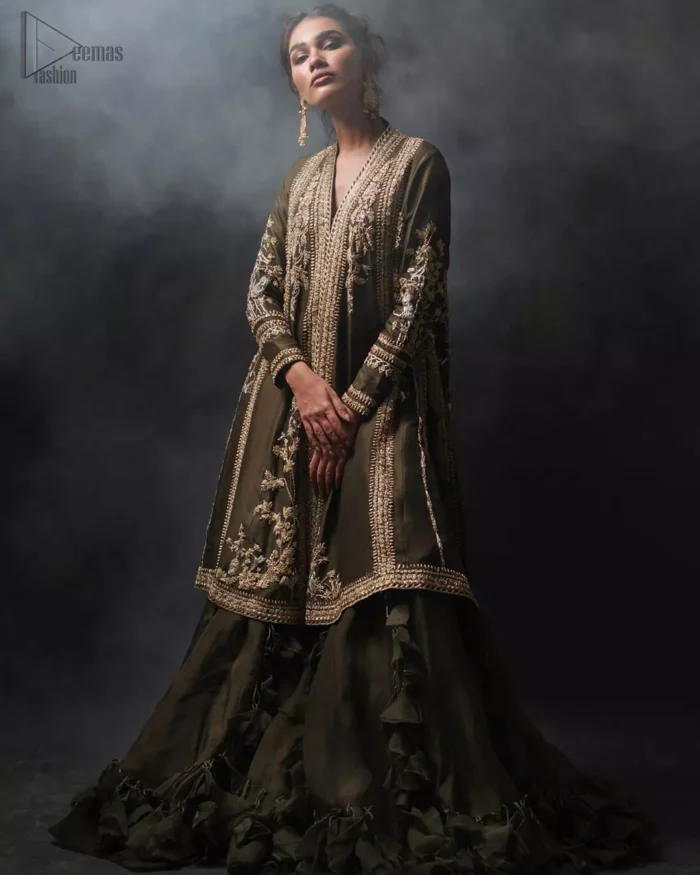 Discover your inner charm with this ravishing front open shirt adorned with golden embellishment. A delicate arrangement of hand embellished floral bunches with zardozi work. Full sleeves and side slits are also decorated with kora, dabka, tilla and sequins work all over. It is coordinated with frilled sharara gives it a perfect look. Style it up with olive green dupatta sprinkled with sequins.
