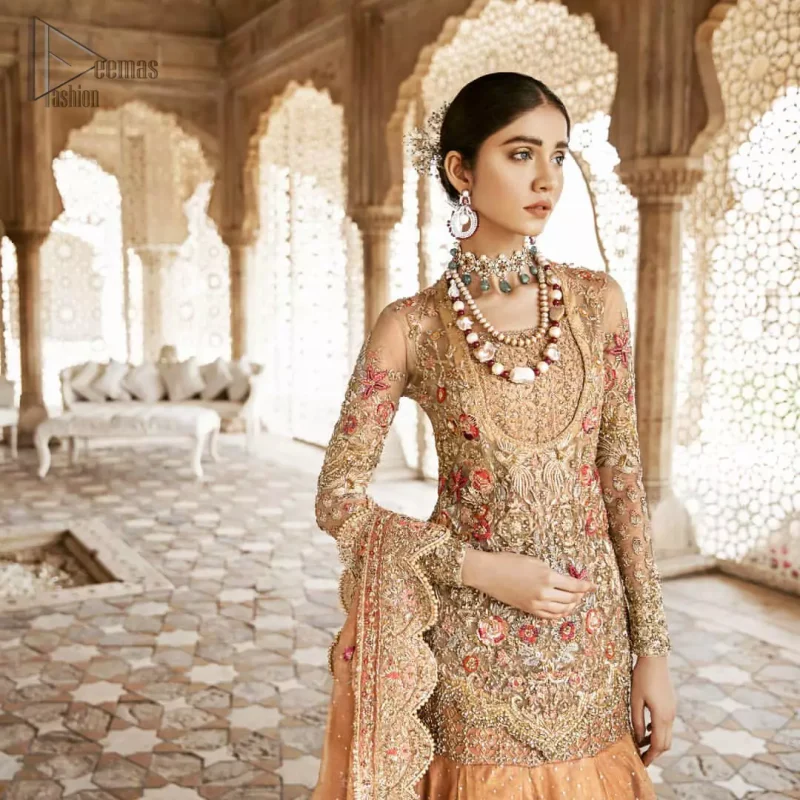 Beautifully elegant with a modern twist. Adorned in an orange embellished with antique detailing all over, this undeniably elegant attire will elevate your style. The shirt is ornamented with antique zardozi and multiple color embroidery detailing all over and vibrant floral motifs. Furthermore the hemline of the shirt is in cutwork style which adds twist. Paired it up with heavily embellished lehenga. The dupatta incorporates beautifully designed scalloped borders on all four sides, focusing on the heavily embellished pallu borders to give it a perfect look.