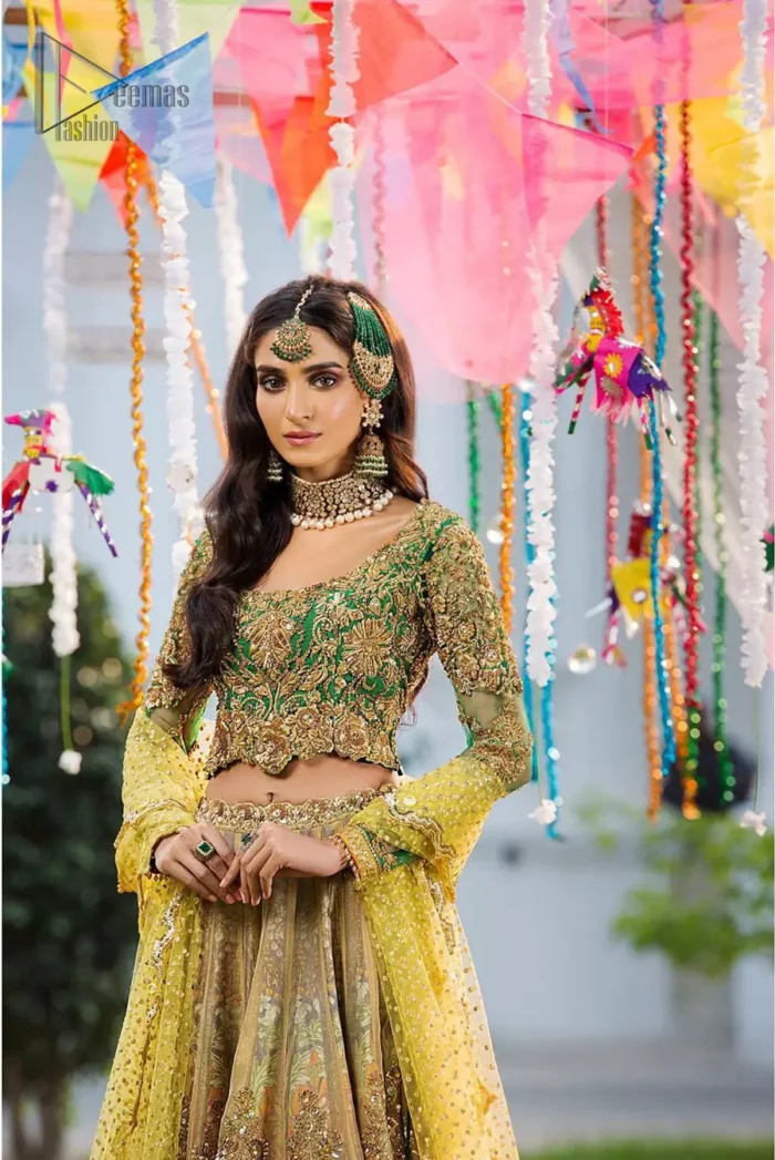 A perfectly pretty combination for a mehndi function. Gussy up the glamour with this intricate embroidered blouse accentuated with golden kora, dabka and tilla work and scalp finishing. The lehenga is emphasized with traditional style done with zardozi work in the shade of golden. Furthermore it is adorned with multiple color applique bottom which complete the look. It is coordinated with yellow dupatta sprinkled with sequins on the ground and scallop border. 