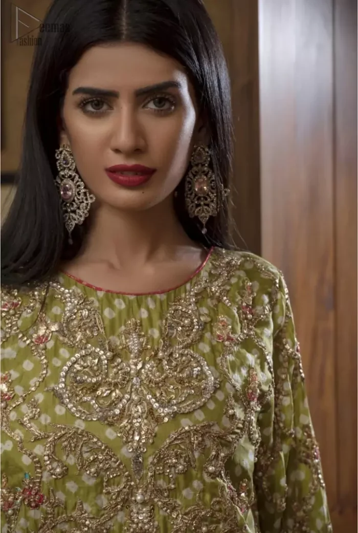Brighten up your look with this beautiful mehndi dress comes with a beautiful parrot green shirt. This shirt is adorned with light gold kora, dabka, tilla and sequins work, furthermore the hemline is enhanced with applique embellishment. Paired it up with traditional jamawar gharara ornamented with zardozi work and finished with lace embellished border. It is coordinated with parrot green dupatta dyed from pallu in two colors and adorned with applique embellished border.