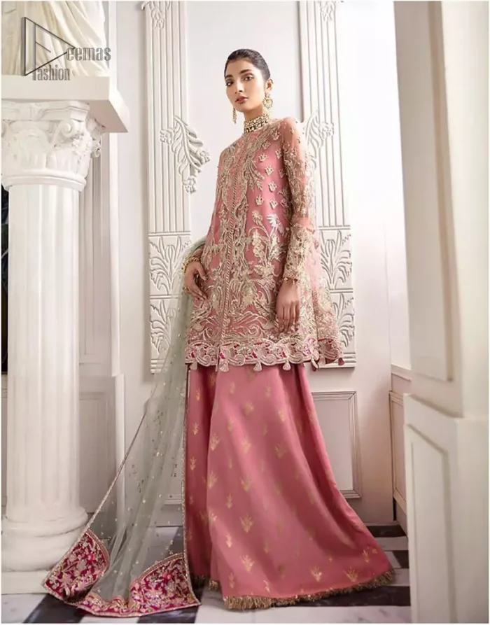 Let the crowd stare and make it worth their while when you walk wearing this outfit. A perfect ensemble for this festive season with divine detailing of thread embroidery, color balance and well-crafted applique hemline. The front open frock is fully embellished with floral embroidery done with light golden zardozi work and thread embroidery. It comprises with pink self fabric sharara and mint green dupatta, adorned with sequins spray on the ground and embellished pink applique pallu. You would definitely want to wear this for your next occasion.