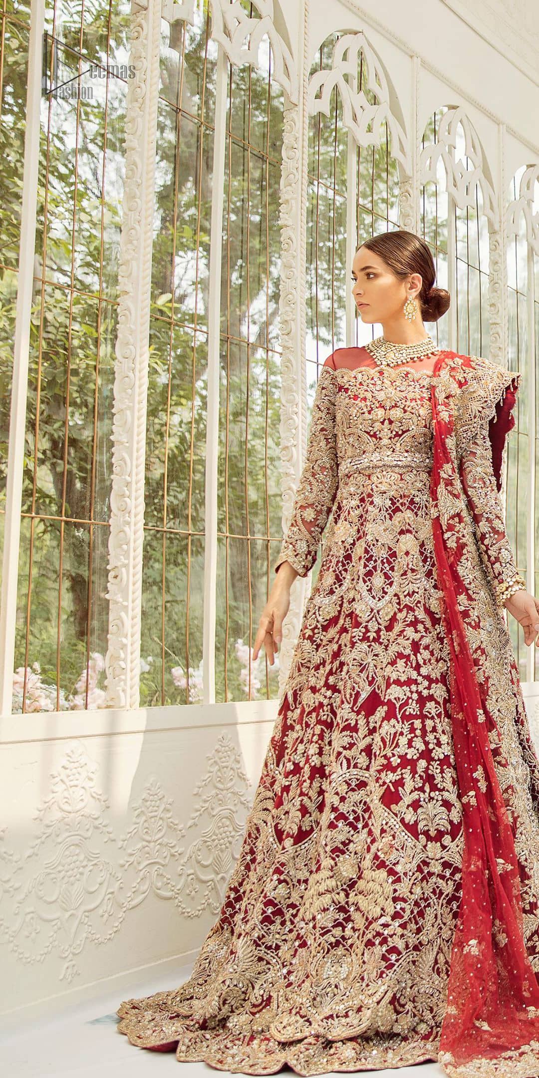 This bridal dress is perfect for your big day. Our bride makes a statement in this stunningly floraison, perfect blend of glamour and tradition with outstanding craftsmanship and gorgeous detailing. This floor length maxi is beautifully sculptured floral jhaal, floral bunches and thick scalloped hemline done with light golden kora, dabka, tilla and sequins embroidery. Exude elegance with red lehenga finessed with beautiful embellished scalloped bottom with zardosi work. The red net dupatta with chann and finishing all around the edges makes the look complete.