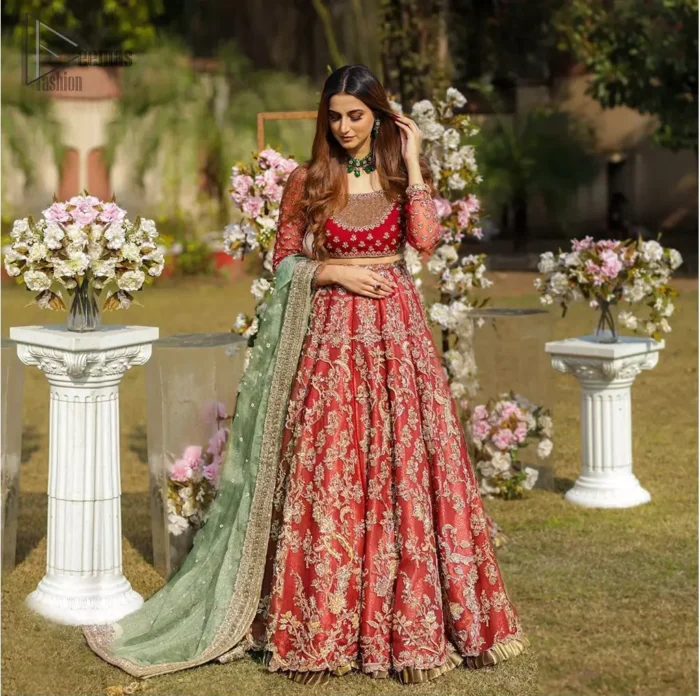 Make a special day even more magic with our exquisite bridal dress. This wedding dress is elegant and eye-catching in equal measure. Strike a breathtakingly elegant pose in this wedding dress, designed with a beautiful neckline embellished with sequins details and scattered tiny floral motifs all over. The lehenga is decorated with floral embroidery all over and finished with frilled fabric. The mint green organza dupatta with chann and finishing all around the edges makes the look complete.