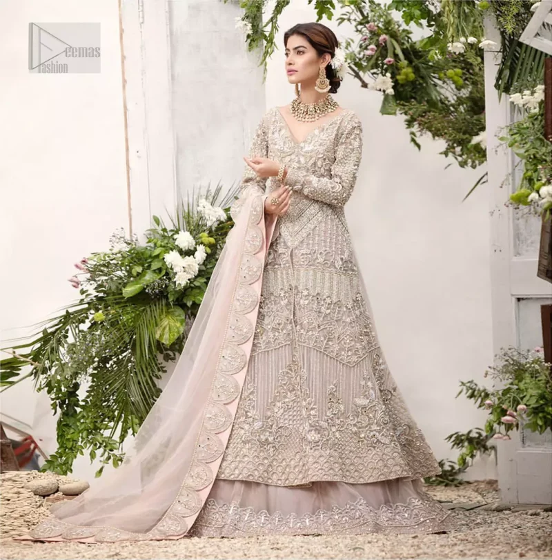 Make a special day even more magic with our exquisite flora bridal maxi dress. Discover classic look in this outfit for a traditional style, with delicate detailing and intricate accents for a subtle yet sophisticated look, having full sleeves with zardozi details. Furthermore the hemline is emphasized with a large central motif and small motifs around it that gives perfect ending to the outfit. It comes with tea pink lehenga with zardozi details on the bottom. Paired with light purple net dupatta sprinkled with sequins and four sided embellished border that gives the right amount of glamour to the outfit.