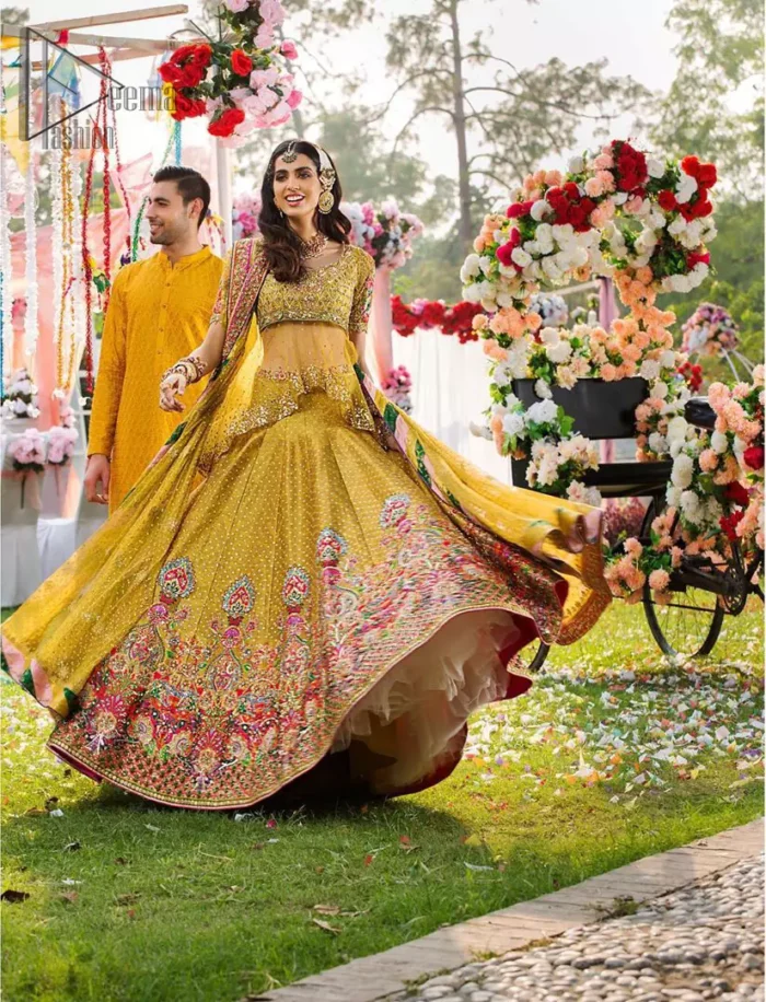 The perfect choice for Mahendi. Delicately crafted and personifying chic elegance with an element of grandiose. The shirt is emphasized with traditional neckline and a small back train. And the lehenga is decorated with intricate floral daaman enhanced with multiple color thread embroidery and rich zardozi work. Paired it up with yellow net dupatta sprinkled with sequins on the ground and four sided applique border.