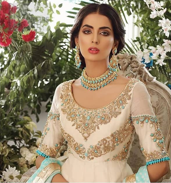 This outfit should be the next addition to your wardrobe. An example of beauty and elegance. Look breathtakingly stylish in this embroidered regalia furnished with intricate embroidered neckline which is embellished with antique shaded zardozi work and ferozi stones. Furthermore, this multiple panel frock is adorned with different sized motifs scattered all over the frock. It is coordinated with ivory churidar pajama. Finished the look with self printed chiffon dupatta having four sided applique on it.