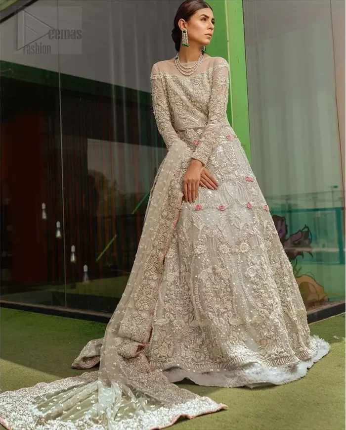 This garnet ensemble is sure to make you look like glamorous royalty with immaculate work covering every inch of the maxi. With a flowing train, this is an ensemble that deserves to be flaunted. The maxi is crafted artfully with silver zardozi work and multiple color thread embroidery. The bodice is heavily decorated with silver kora, dabka and tilla work. Furthermore, scattered sequins all over to give it a perfect look. Balance the look with light gray lehenga adorned with frilled bottom. Dupatta is decorated with vintage floral on pallus and finished with embroidered border on four sides which makes this outfit more beautiful.