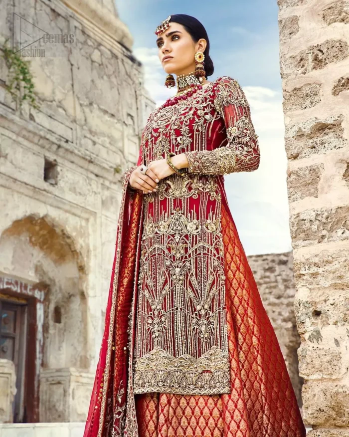 You are all set to make a lasting impact with the divine royalty of this dress. This beautiful dress comes with a maroon back train lehenga with beautiful embellishment around the hem. The shirt is adoned with golden zardozi work around the neckline and vertically worked gold lines and it finished with a thick embellished border. The sleeves are embellished with motifs all over along with a thick embroidered border. The dupatta incorporates beautifully designed borders on all four sides, focusing on the heavily embellished pallu borders to give it a perfect maharani look.