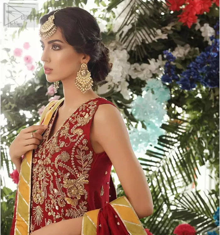 Tradition meets modernity. Boost your confidence and style in this glamorous attire accentuated with finest zardozi work embroidery and scalloped borders with dandling pearls. This maroon sleeveless shirt is ornamented with golden and light golden zardozi work. The scalloped hemline is decorated with dangling pearls. Style it confidently with maroon sharara adorned with beautiful gota work. It is paired with an ethereal maroon dupatta with scattered sequins all over and four sided applique borders.